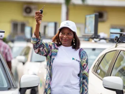 Une bénéficiaire devant son Taxi